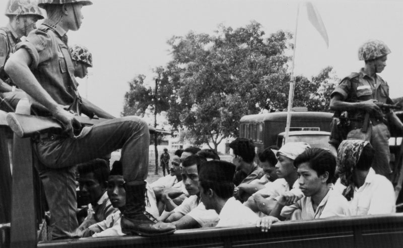 FILE - Members of the Youth Wing of the Indonesian Communist Party (Pemuda Rakjat) are watched by soldiers as they are taken to prison in Jakarta following a crackdown on communists after an abortive coup against President Sukarno's government earlier in the month, on October 30, 1965. Photo: AP