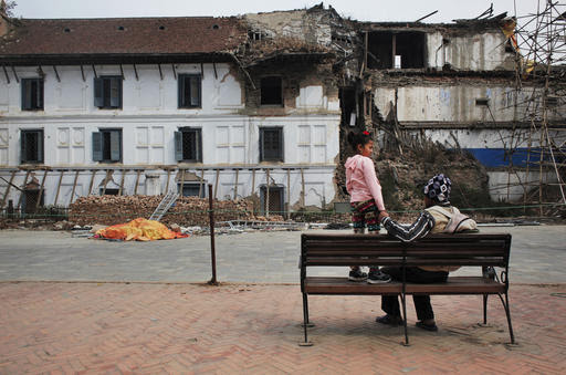 In this March 12, 2016 photo, Chitra Pariyar and his daughter Nirmala, 8, rest on a bench in Basantapur Durbar Square, Kathmandu, Nepal. Nirmala lost a leg in Nepal's massive April 2015 earthquake that killed nearly 9,000 people dead and more than 22,000 injured. (AP Photo/Niranjan Shrestha)