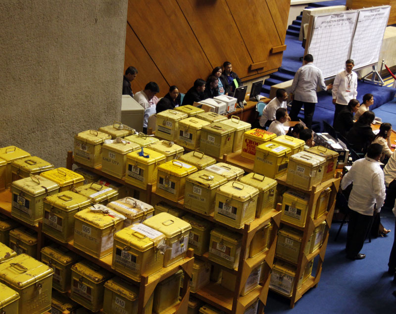 FILE - Security personnel and staff members of the Lower House keep a close eye on ballot boxes containing certificates of canvass, during the second day of deliberations of the National Board of Canvassers at the House of Representatives in Quezon City north of Manila, Philippines, on Wednesday, May 26, 2010. Photo: Pat Roque/AP