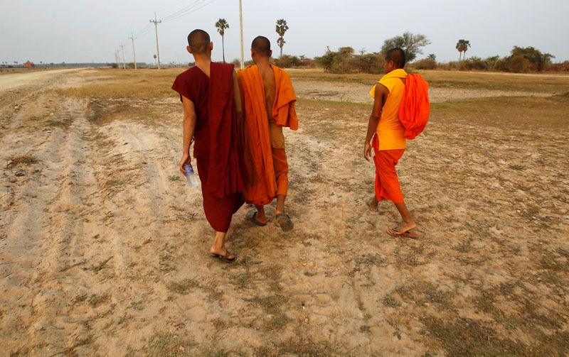 Cambodian Buddhist monks walk through dried earth near pagoda at Trapang Chhouk village in the outskirt of Phnom Penh, Cambodia, on March 25, 2016. Photo: Heng Sinith/AP