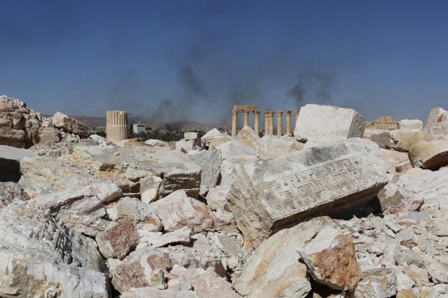 Smoke rises from the modern city as seen from the historic city of Palmyra, in Homs Governorate, Syria April 1, 2016. REUTERS/Omar Sanadiki