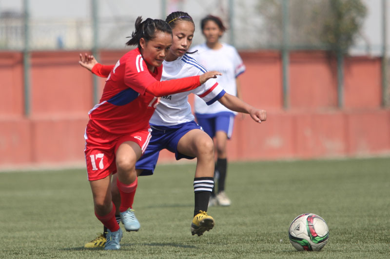 Tribhuvan Army Club's Bhujanga Rai (left) vies for the ball with an Western Region player during their Womenu0092s National Football League match at the ANFA Complex grounds in Lalitpur on Wednesday. Photo: Udipt Singh ChhetryTHT