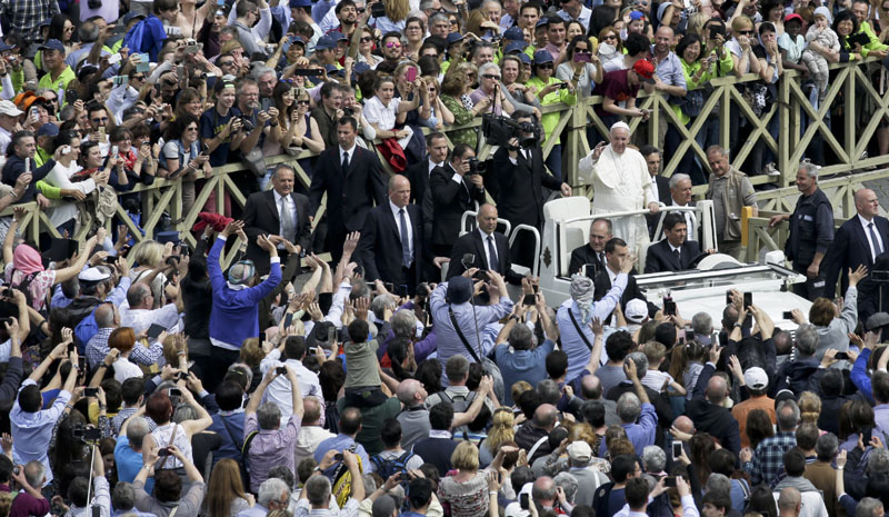 Faithful and tourists photograph Pope Francis as he makes a tour of St. Peter's Square at the end of a Mass for the the Holy Year of Mercy, at the Vatican, on Sunday, April 3, 2016. Photo: AP