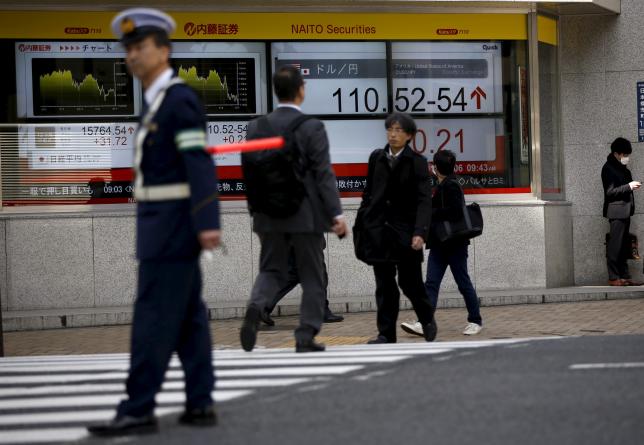 Electronic boards show the exchange rate between Japanese yen against the U.S. dollar as a police officer (L) controls the traffic in front of a brokerage in Tokyo, Japan April 6, 2016. REUTERS/Issei Kato