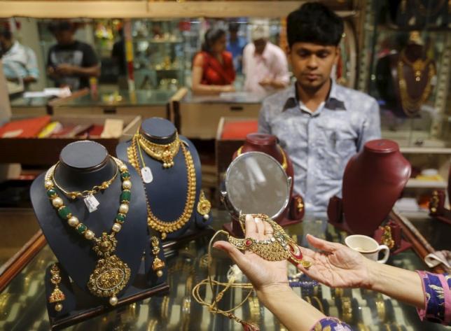 A customer tries a gold necklace at a jewellery showroom at a market in Mumbai, India, November 9, 2015. REUTERS/Shailesh Andrade