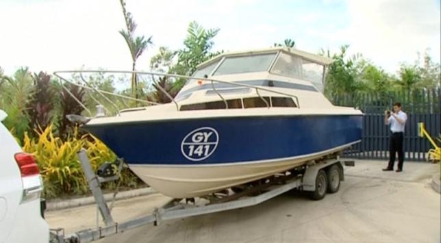 An officer takes pictures of a boat, which Australian police have seized in Cairns, Queensland, Australia in this still image taken from video, May 11, 2016. Australian Broadcasting Corporation/Handout via REUTERS TV