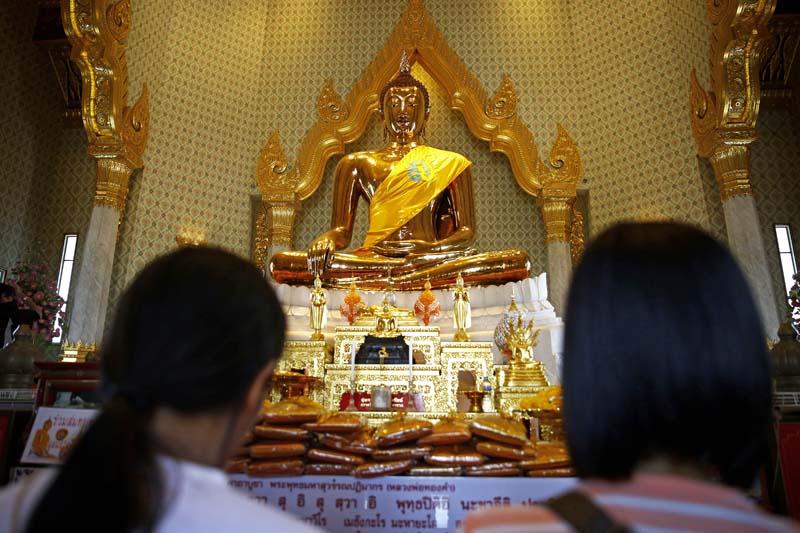 Devotees offer prayer in front of the largest golden statue of Lord Buddha, as the world celebrates 2560th Buddha Jayanti, inside a temple in Bangkok, Thailand, on Saturday, May 21, 2016. Photo: Skanda Gautam/ THT