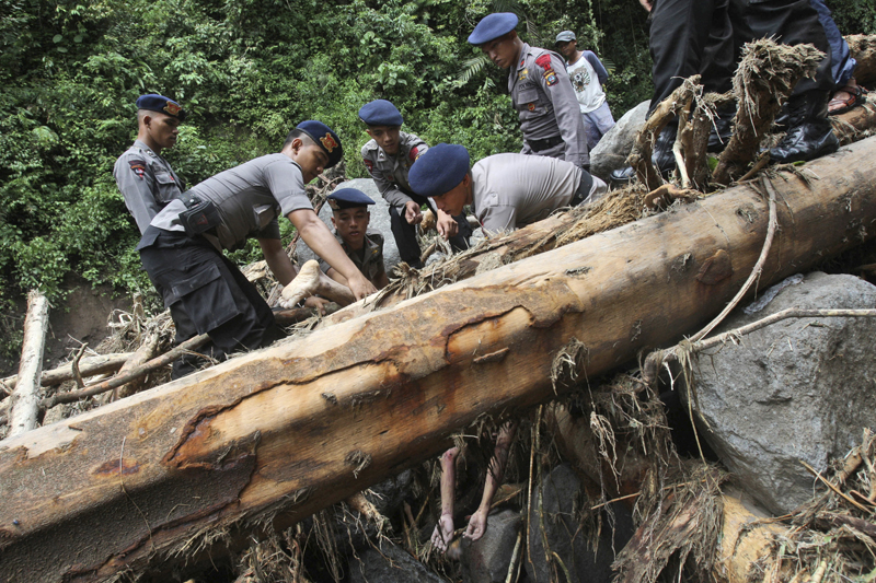 Rescuers recover the body of a victim after a flood hit Dua Warna waterfall in Sibolangit, North Sumatra, Indonesia, Monday, May 16, 2016. Photo: AP