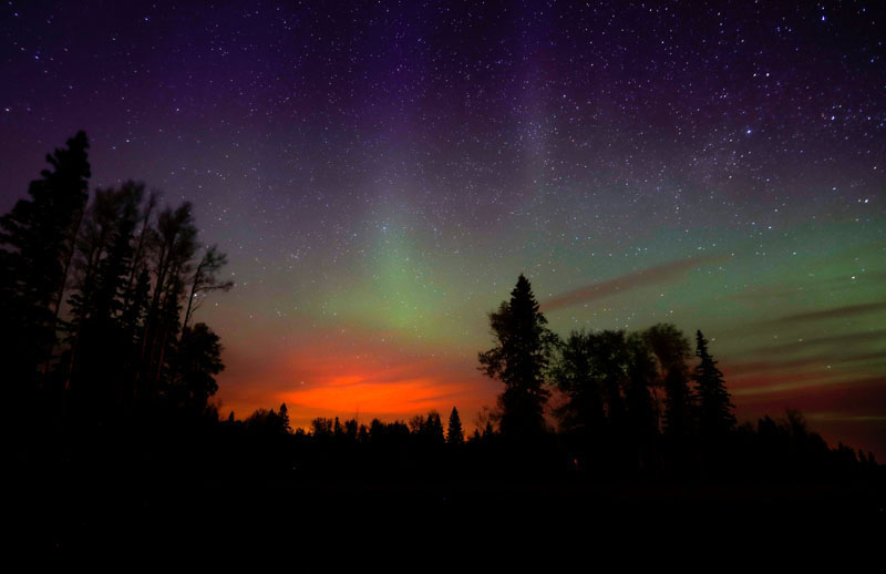 The wildfires glow underneath The Northern Lights, also known as the Aurora Borealis, near Fort McMurray, Alberta, Canada, on May 7, 2016. Photo: Mark Blinch/Reuters
