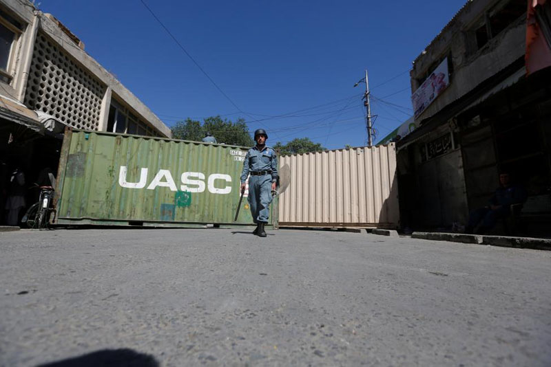 An Afghan policeman keeps watch in front of shipping containers that blocked streets leading to Kabul's government and diplomatic area in Kabul, Afghanistan May 16 , 2016. Photo: Omar Sobhani/Reuters