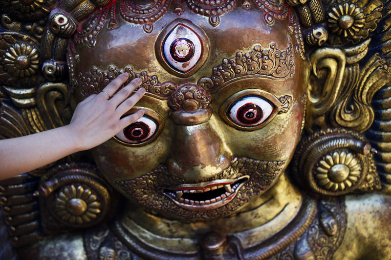 A devotee (face unseen) pays tribute to the idol of Lord Bhairava placed on the chariot of Rato Machhindranath during the chariot festival in Lalitpur, on Thursday, May 12, 2016. Photo: Skanda Gautam