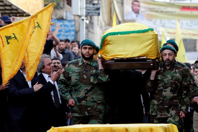 Hezbollah members carry the coffin of top Hezbollah commander Mustafa Badreddine, who was killed in an attack in Syria, as his brother mourns his death during his funeral in Beirut's southern suburbs, Lebanon, May 13, 2016. REUTERS/Jamal Saidi