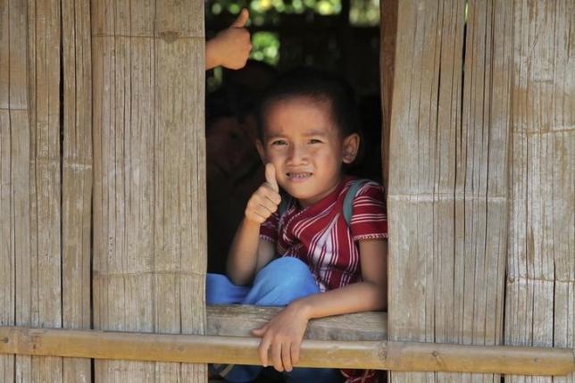 A primary school student at the Ei Thu Ta camp for displaced Karens along the Salween river in Myanmar gives a thumb-up November 17, 2014.  REUTERS/Thin Lei Win/Files