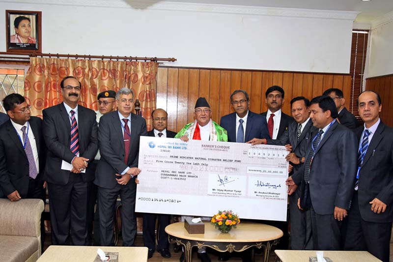 Prime Minister KP Sharma Oli receives the cheque of Rs 52.1 million from representatives of the SBI Nepal for the PMu2019s Disaster Relief Fund, in his office, Baluwatar, on Sunday, May 15, 2016. Photo: RSS