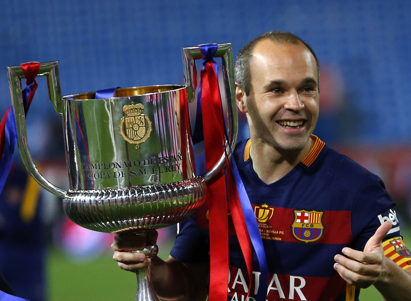 Barcelona's Andres Iniesta carries the trophy after winning the final of the Copa del Rey soccer match between FC Barcelona and Sevilla FC at the Vicente Calderon stadium in Madrid, on Sunday, May 22, 2016. Barcelona won 2-0 . 