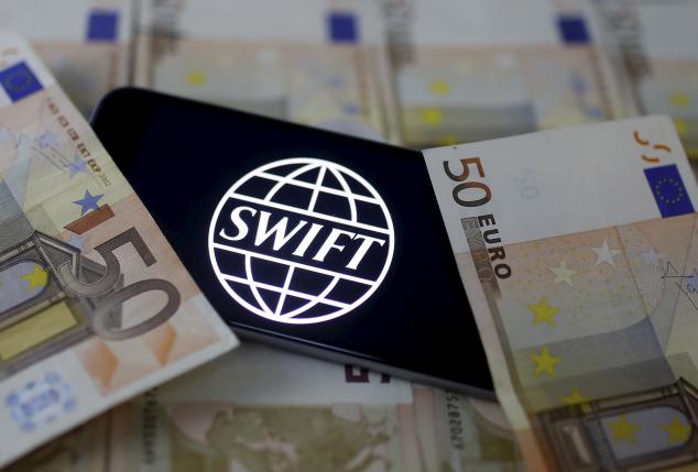 Swift code bank logo is displayed on an iPhone 6s on top of Euro banknotes in this picture illustration made in Zenica, Bosnia and Herzegovina, January 26, 2016.   REUTERS/Dado Ruvic/File Photo