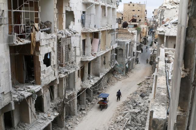 Residents walk near damaged buildings in the rebel held area of Old Aleppo, Syria May 5, 2016. REUTERS/Abdalrhman Ismail