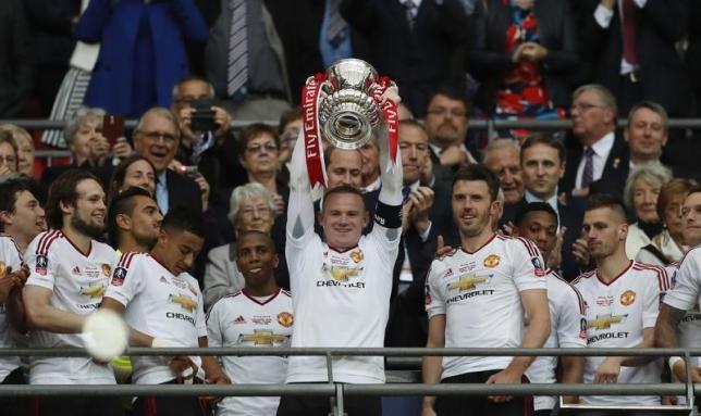 Britain Football Soccer - Crystal Palace v Manchester United - FA Cup Final - Wembley Stadium - 21/5/16nManchester United's Wayne Rooney celebrates with the trophy after winning the FA Cup with teammates.nPhoto: Reuters n