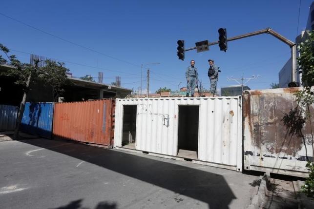 Afghan policemen keep watch on a roof of shipping containers that blocked streets leading to Kabul's government and diplomatic area in Kabul Kabul, Afghanistan May 16, 2016.  REUTERS