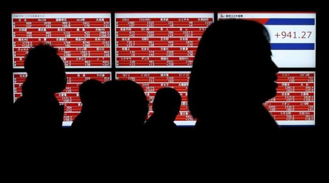 Pedestrians walk past an electronic stock quotation board outside a brokerage in Tokyo, Japan January 22, 2016. REUTERS/Toru Hanai