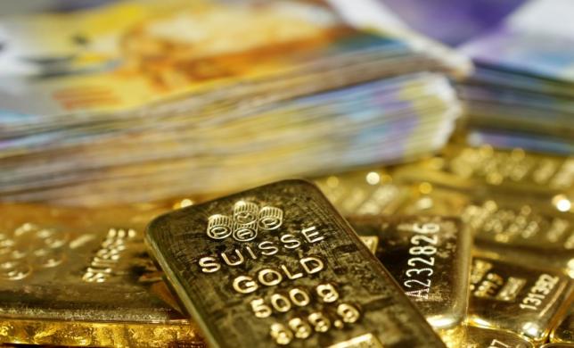 Gold bars and Swiss Franc banknotes are seen in this illustration picture taken at the GSA in Vienna November 13, 2014. REUTERS/Leonhard Foeger