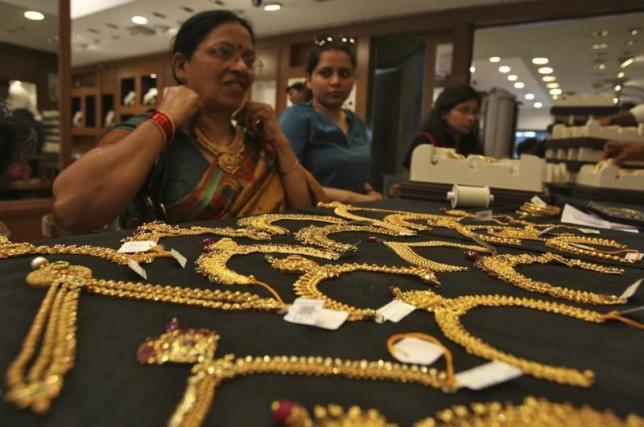 A customer tries on a gold necklace inside a jewellery showroom in Hyderabad April 11, 2012.  REUTERS/Krishnendu Halder