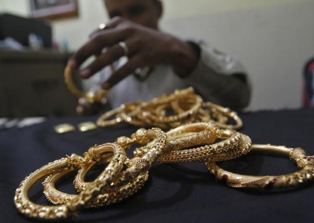 A goldsmith holds finished gold bangles at a workshop in Kolkata January 16, 2013.  REUTERS/Rupak De Chowdhuri