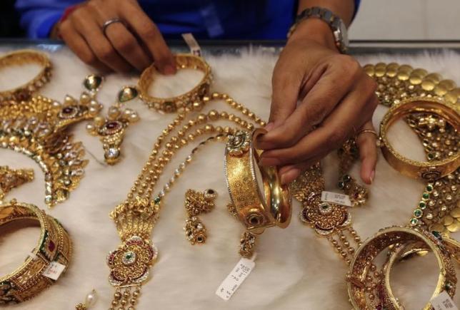 A woman looks at a gold bangle inside a jewellery showroom at a market in Mumbai January 15, 2015. REUTERS/Shailesh Andrade/Files