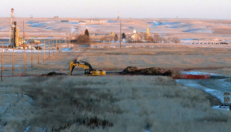 FILE - Crews dig at a spill site where a leak from a four-inch pipeline spilled nearly 3 million gallons of saltwater brine near Blacktail Creek outside Williston, NorthDakota, on January 12, 2015. Photo: Zack Nelson/Williston Herald via AP