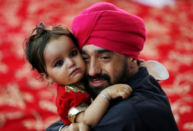 An Afghan Sikh holds his child inside a Gurudwara, or a Sikh temple, during a religious ceremony in Kabul, Afghanistan June 8, 2016.  REUTERS/Mohammad Ismail