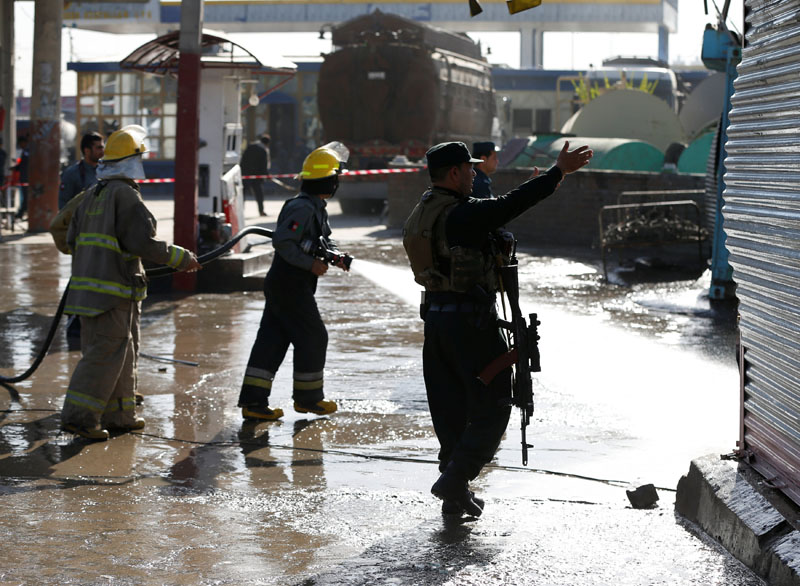 Afghan fire fighters and members of security forces clean the site of suicide attack in Kabul. Reuters