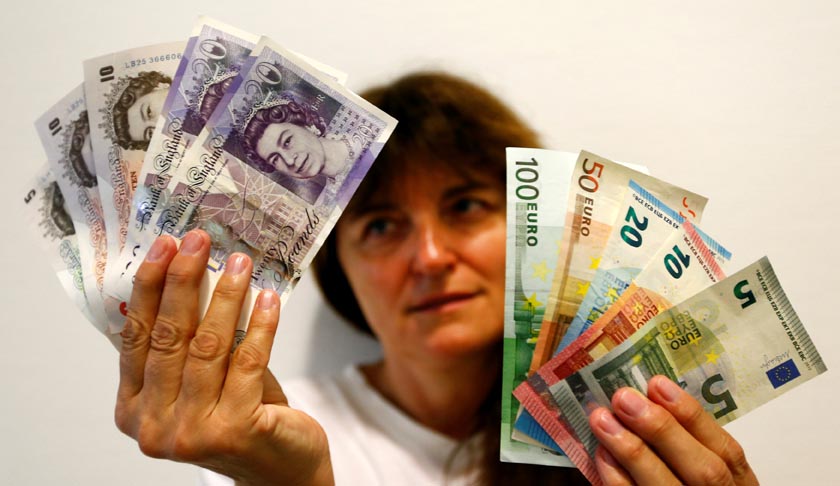 An employee holds British pounds and Euro banknotes in a bank at the main train station in Munich, Germany, June 24, 2016 after Britain voted to leave the European Union in the EU BREXIT referendum.    REUTERS/Michaela Rehle