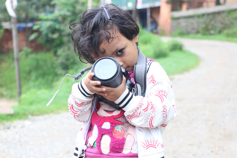 A child plays with an SLR camera in Kakani of Nuwakot district, on Wednesday, June 22, 2016.  Photo: RSS