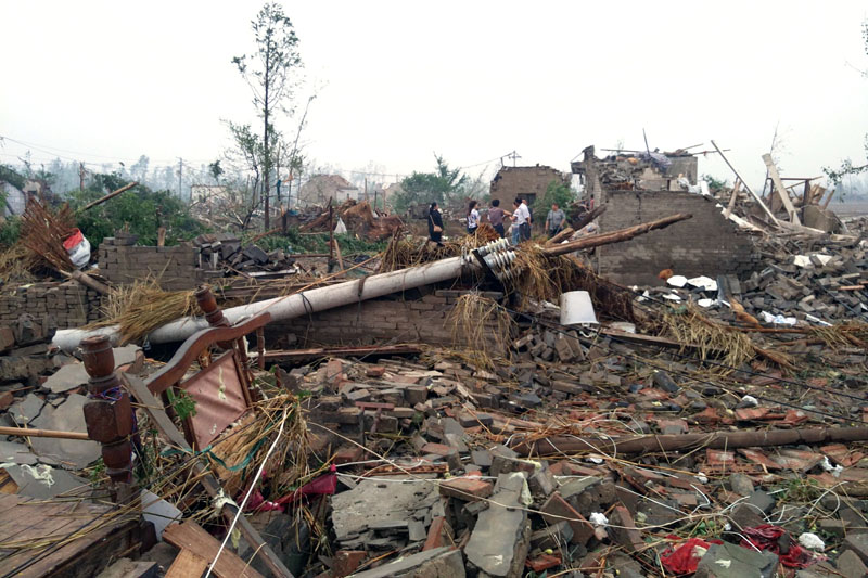 Residents pass houses destroyed in the aftermath of a tornado that hit Funing county, in Yancheng city in eastern China's Jiangsu Province on Thursday, June 23, 2016. A powerful tornado killed dozens and destroyed large numbers of buildings Thursday in the eastern Chinese province of Jiangsu, state media reported. Photo: Color China Photo via AP
