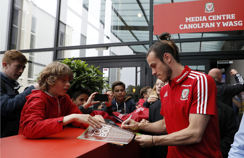 Wales' Gareth Bale signs autographs as he leaves the news conference at COSEC Stadium, Dinard, in France, on Wednesday, June 29, 2016. Photo: Reuters
