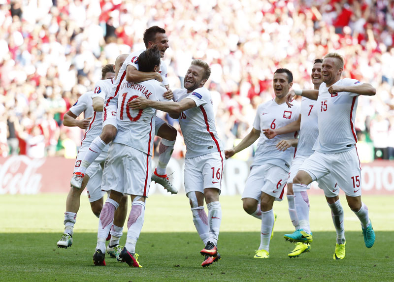 Poland's Grzegorz Krychowiak celebrates with teammates after scoring the final and decisive penalty kick during the Euro 2016 round of 16 soccer match between Switzerland and Poland, at the Geoffroy Guichard stadium in Saint-Etienne, France, on Saturday, June 25, 2016. Photo: Reuters