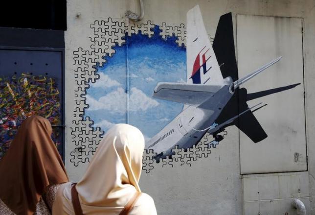 Women look at a mural of missing Malaysia Airlines flight MH370 two years after it disappeared, in Kuala Lumpur, Malaysia, March 7, 2016. REUTERS/Olivia Harris/Files