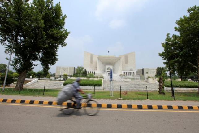 A man rides a bicycle past the Supreme Court building in Islamabad, Pakistan, June 27, 2016. REUTERS/Faisal Mahmood