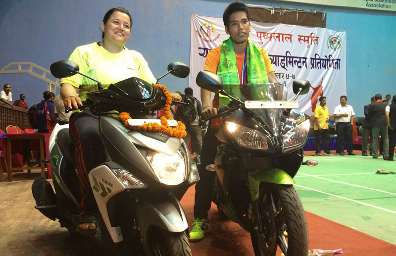 Ratnajit Tamang of Tribhuvan Army Club and Puja Shrestha of Nepal APF Club ride on two-wheelers after the fifth Pushpalal Memorial National Ranking Badminton Tournament in Kathmandu on Tuesday, June 21, 2016. Photo: THT