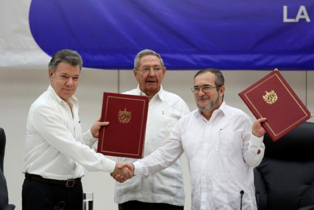 Cuba's President Raul Castro (C), Colombia's President Juan Manuel Santos (L) and FARC rebel leader Rodrigo Londono, better known by his nom de guerre Timochenko, react after signing a historic ceasefire deal between the Colombian government and FARC rebels in Havana, Cuba, June 23, 2016. REUTERS/Alexandre Meneghini