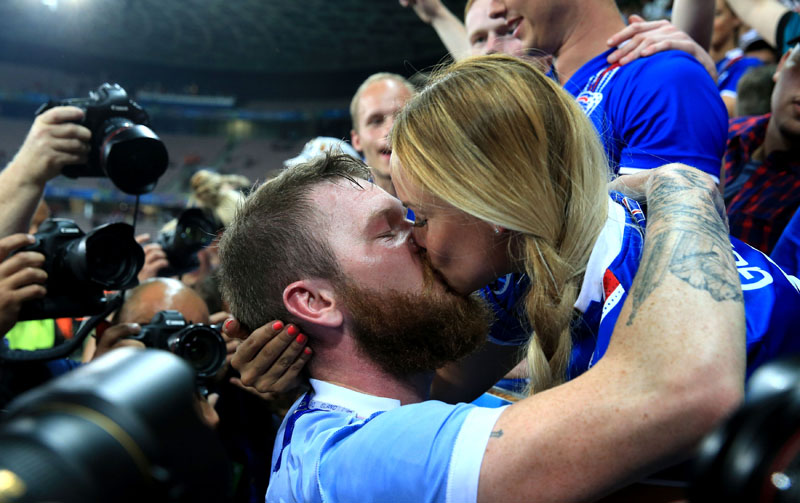 Iceland's soccer player Aron Gunnarsson kisses his partner Kris J as he celebrates victory in the Round of 16 soccer match at Stade de Nice, Nice, France, on Monday June 27, 2016. Iceland pulled off the shock of the European Championship by beating England 2-1 in the round of 16 on Monday, continuing the improbable run of the smallest nation at the tournament. Photo: Nick Potts / PA via AP