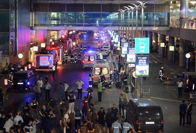 Medics and security members work at the entrance of the Ataturk Airport after explosions in Istanbul, on Tuesday, June 28, 2016. Photo: IHA via AP