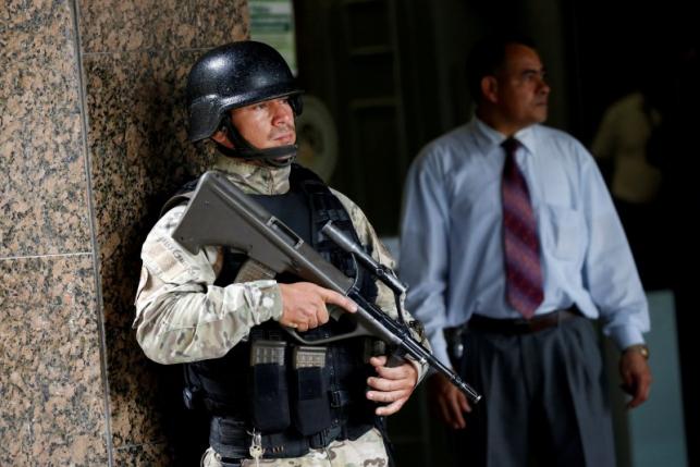 An armed special police officer stands guard outside Venezuela's Central Bank building in Caracas, Venezuela June 20, 2016. REUTERS/Carlos Garcia Rawlins