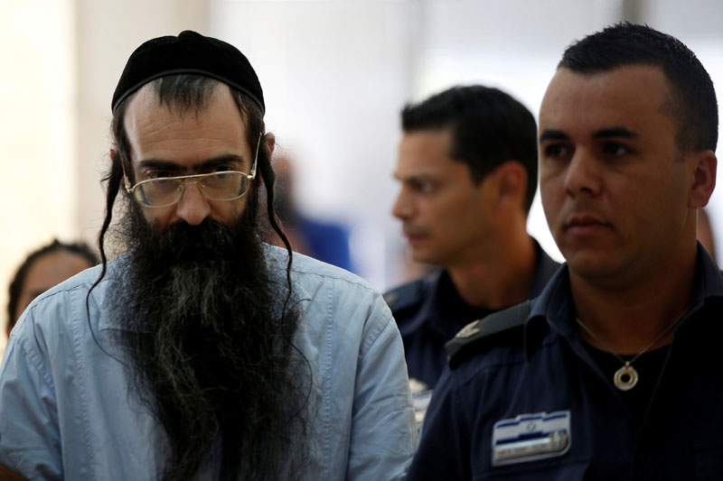 Yishai Schlissel (C), convicted of killing a woman during the 2015 Jerusalem Gay Pride Parade, is escorted by security personnel befire he is sentenced at the Jerusalem District Court June 26, 2016. Photo: Reuters/File