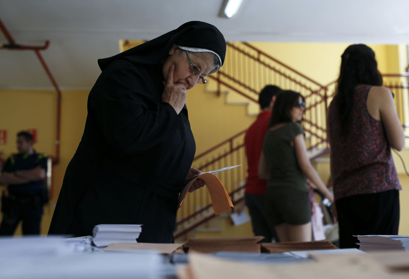 A nun looks at ballot papers at a polling station before voting in Spain's general election in Madrid, Spain, June 26, 2016.  photo: Reuters/File