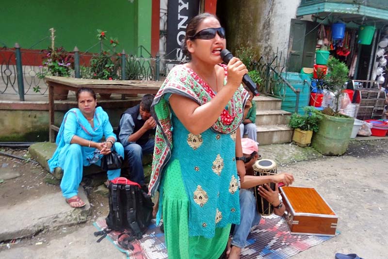 A visually-impaired woman sings a song as a means of earning in the district headquarters Ilam, on Monday, June 27, 2016. Photo: RSS