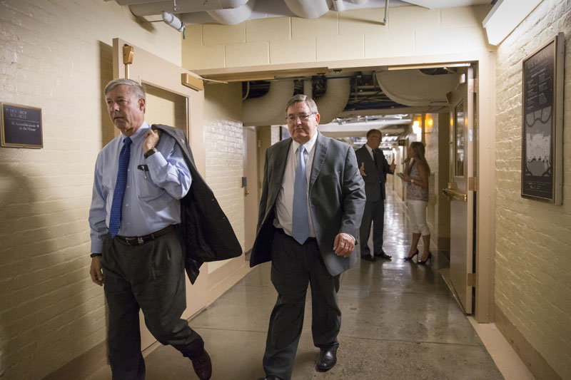 House Energy and Commerce Committee Chairman Representative Fred Upton, R-Mich (left), Representative Michael C Burgess, R-Texas (right) and other House Republicans rush to a closed-door GOP caucus with House Speaker Paul Ryan of Wisconsin, on Capitol Hill in Washington, on Tuesday, July 12, 2016. Photo: AP