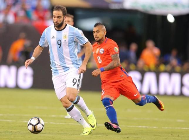 Jun 26, 2016; East Rutherford, NJ, USA; Argentina forward Gonzalo Higuain (9) dribbling the ball past Chile midfielder Arturo Vidal (8) during the first half of the championship match of the 2016 Copa America Centenario soccer tournament at MetLife Stadium. Mandatory Credit: Brad Penner-USA TODAY Sports