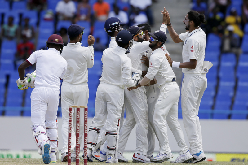 Indian players surround captain Virat Kohli after he caught West Indies' Jermaine Blackwood, left, during day four of their first cricket Test match at the Sir Vivian Richards Stadium in North Sound, Antigua, Sunday, July 24, 2016. Photo: AP