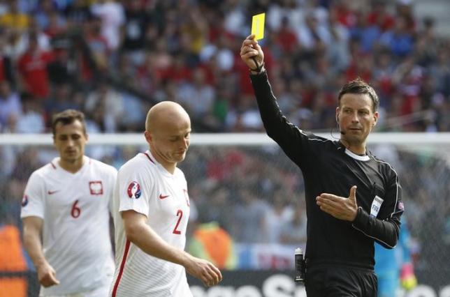 Football Soccer - Switzerland v Poland - EURO 2016 - Round of 16 - Stade Geoffroy-Guichard, Saint-?tienne, France - 25/6/16nPoland's Michal Pazdan is shown a yellow card by referee Mark ClattenburgnREUTERS/Yves HermannLivepic